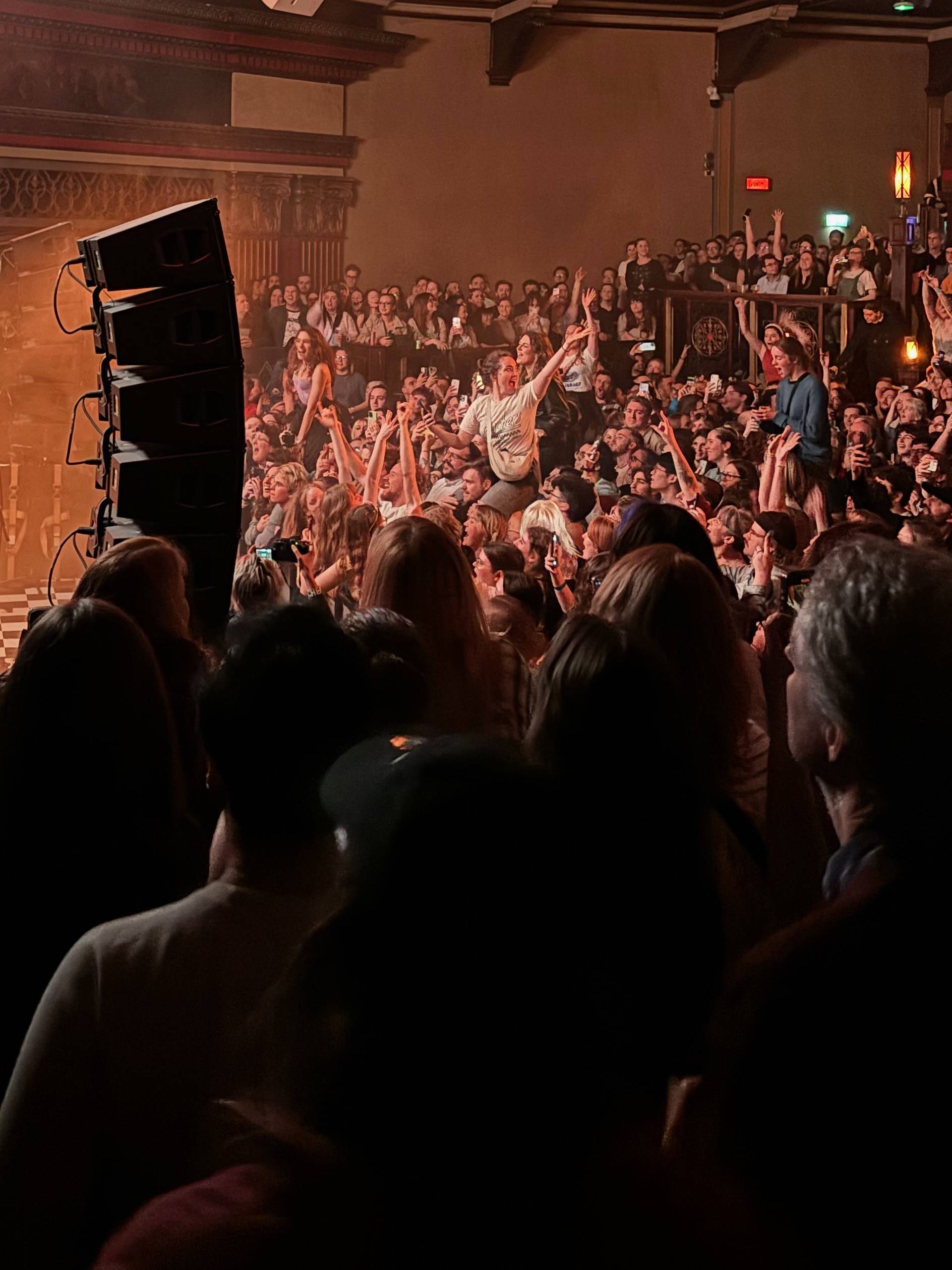 Speaker stacks and a concert crowd.